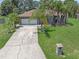 Charming single-story home with a two-car garage, lush lawn and swaying palm trees enhancing its curb appeal at 166 Paradise Island Dr, Haines City, FL 33844
