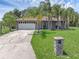 Charming single-story home with landscaped front yard, lush green lawn, and a decorative stone pillar at 166 Paradise Island Dr, Haines City, FL 33844