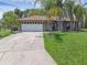 Charming single-story home featuring a well-manicured lawn and tasteful landscaping with palm trees at 166 Paradise Island Dr, Haines City, FL 33844