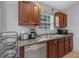 Functional kitchen area with stainless steel dishwasher, granite countertops, and wooden cabinets at 166 Paradise Island Dr, Haines City, FL 33844