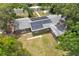 This is an aerial view of the home featuring solar panels on the roof and mature trees at 1800 Banyan St, Orange City, FL 32763