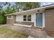 Charming home entrance with a blue front door and well-maintained landscaping at 1800 Banyan St, Orange City, FL 32763