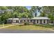 Well-maintained single-story home with lush landscaping and a spacious front yard, complete with solar panels at 1800 Banyan St, Orange City, FL 32763