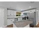 Modern kitchen with white cabinets, stainless steel appliances, and a granite-topped island at 1800 Banyan St, Orange City, FL 32763
