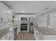 Bright kitchen featuring granite countertops, stainless steel appliances, and white cabinets at 1800 Banyan St, Orange City, FL 32763