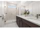 Elegant bathroom featuring double sinks, a walk-in shower, and marble countertops at 1845 Island Village Way, Celebration, FL 34747