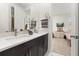 Bathroom with double vanity, dark wood cabinets, and a view to the bedroom at 1845 Island Village Way, Celebration, FL 34747