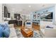 Spacious living room with kitchen view, hardwood floors, and stylish modern furniture at 1845 Island Village Way, Celebration, FL 34747