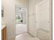 Bathroom featuring an open closet, view into bedroom with window, and neutral tile floor at 2050 Island Walk Dr, Orlando, FL 32824