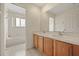 Bright bathroom features double sinks, wood cabinets, and a combined tub and shower at 2050 Island Walk Dr, Orlando, FL 32824