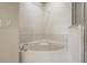 Corner soaking tub with white tile surround, chrome fixtures, and glass shower doors at 2050 Island Walk Dr, Orlando, FL 32824