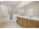Bathroom featuring double sinks with wooden cabinets, a walk-in shower, and a soaking tub at 2050 Island Walk Dr, Orlando, FL 32824