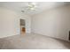 Bright bedroom with neutral walls and carpet, featuring a ceiling fan and open doorway to the bathroom at 2050 Island Walk Dr, Orlando, FL 32824
