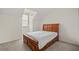 Bedroom featuring a wooden bed frame, large window, and neutral walls and carpet at 2050 Island Walk Dr, Orlando, FL 32824