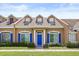 Charming townhome featuring a blue door, blue shutters, and manicured landscaping at 2050 Island Walk Dr, Orlando, FL 32824
