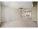 Open living room with neutral walls and carpet, ceiling fan, and arched doorway to the porch with double doors at 2050 Island Walk Dr, Orlando, FL 32824