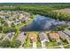 Aerial view of homes surrounding a lake with wooded area nearby at 2054 Hammock Moss Dr, Orlando, FL 32820