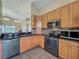 Corner kitchen features wooden cabinets, black appliances, and granite countertops at 2054 Hammock Moss Dr, Orlando, FL 32820