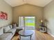 Cozy living room with high ceiling, sofa, hardwood floors, and relaxing pond view outside window at 2054 Hammock Moss Dr, Orlando, FL 32820