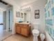 Well-lit bathroom with wood vanity, framed mirror, and a shower-tub with seashell shower curtain at 2649 Hemingway Ave, Haines City, FL 33844