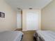 Bedroom with two twin beds, neutral bedding, closet with sliding doors and wall art at 2649 Hemingway Ave, Haines City, FL 33844