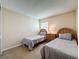 Bedroom with two twin beds, neutral bedding, side table with lamp, and a window at 2649 Hemingway Ave, Haines City, FL 33844