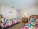 Bedroom featuring two twin beds with colorful floral bedding, and a bedside table with lamp at 2649 Hemingway Ave, Haines City, FL 33844