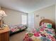 Bedroom featuring two twin beds with colorful floral bedding, closet, and a window at 2649 Hemingway Ave, Haines City, FL 33844