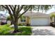 Charming home featuring a large tree, well-maintained lawn, and a two-car garage at 2649 Hemingway Ave, Haines City, FL 33844