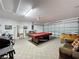 Spacious game room featuring a pool table, foosball table, and comfortable seating area for entertaining guests at 2649 Hemingway Ave, Haines City, FL 33844