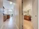 Hallway view to a bathroom with a wood vanity and a kitchen with stainless appliances at 2649 Hemingway Ave, Haines City, FL 33844