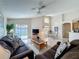 Open living room featuring tile flooring, a ceiling fan, and sliding doors to the patio at 2649 Hemingway Ave, Haines City, FL 33844