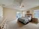 Comfortable main bedroom with a ceiling fan, neutral walls, and sliding glass doors to the pool area at 2649 Hemingway Ave, Haines City, FL 33844