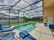 Screened-in pool with patio and lawn chairs providing a private outdoor retreat at 2649 Hemingway Ave, Haines City, FL 33844