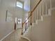 Bright foyer features a high ceiling, tiled floor, and a staircase with wooden handrails at 2735 Scarborough Dr, Kissimmee, FL 34744