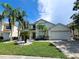 Charming two-story home with a well-manicured lawn, palm trees, and a spacious three-car garage at 2735 Scarborough Dr, Kissimmee, FL 34744