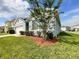 Side view of the home featuring lush lawn and landscaping, nestled in a quiet neighborhood at 2839 Harmonia Hammock Rd, Harmony, FL 34773