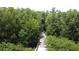 Scenic aerial view of a wooden boardwalk trail winding through lush green trees and foliage at 2924 White Cedar Cir, Kissimmee, FL 34741