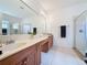 Bathroom featuring double sinks, a large mirror, and a walk-in shower with glass door at 2924 White Cedar Cir, Kissimmee, FL 34741