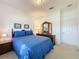 This bedroom is furnished with a queen bed, side table, and dresser with a mirror at 2924 White Cedar Cir, Kissimmee, FL 34741