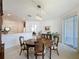 Open dining room with view to the kitchen, with chandelier and sliding glass doors at 2924 White Cedar Cir, Kissimmee, FL 34741