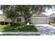Well-maintained home with manicured lawn, mature trees, and a two-car garage at 2924 White Cedar Cir, Kissimmee, FL 34741