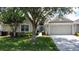 Inviting home exterior with a lush green lawn, mature trees, and a well-maintained landscape at 2924 White Cedar Cir, Kissimmee, FL 34741