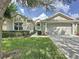 Charming single-story home with a manicured lawn, blue front door, and two-car garage at 2924 White Cedar Cir, Kissimmee, FL 34741