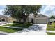 Charming single-story home with a well-manicured lawn, mature trees, and a two-car garage at 2924 White Cedar Cir, Kissimmee, FL 34741