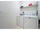Functional laundry area features a washer and dryer, along with convenient storage shelving at 2924 White Cedar Cir, Kissimmee, FL 34741