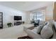 Bright living room with a comfortable gray sofa, large window, and media center with fireplace at 2924 White Cedar Cir, Kissimmee, FL 34741