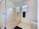 Window and tiled shower stall with grab bar in the bright white bathroom with toilet at 2924 White Cedar Cir, Kissimmee, FL 34741