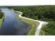 Picturesque aerial view of a walking path beside a lake surrounded by lush greenery at 2924 White Cedar Cir, Kissimmee, FL 34741