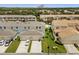 Aerial view of the townhome community showcases garages, green lawns, and lush landscaping at 2966 Aqua Virgo Loop # 16, Orlando, FL 32837